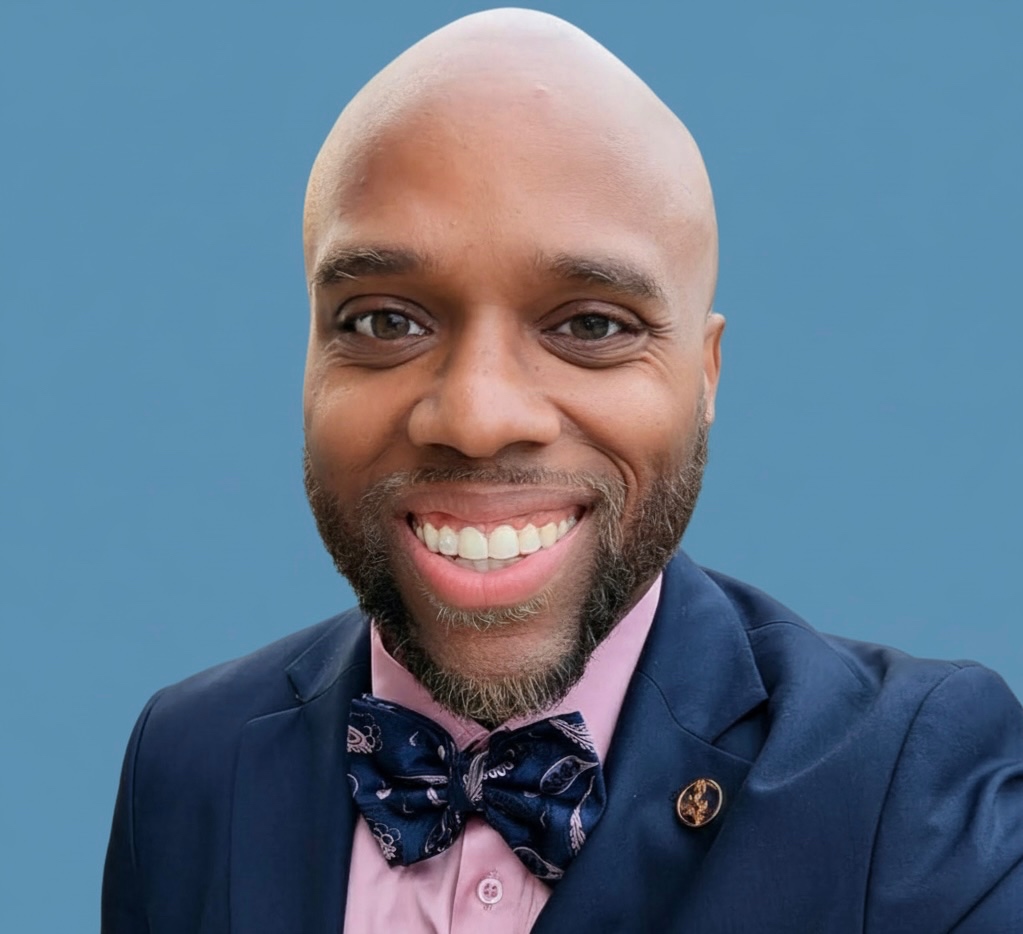 Miles Randall in a navy suit with bow tie and pocket square